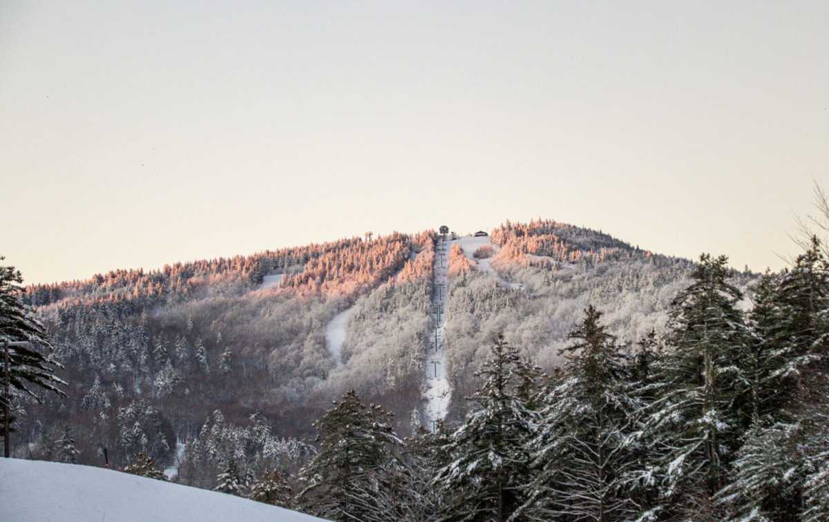 A panoramic mountain scene after spring snowfall, showcasing snowy slopes and clear skies